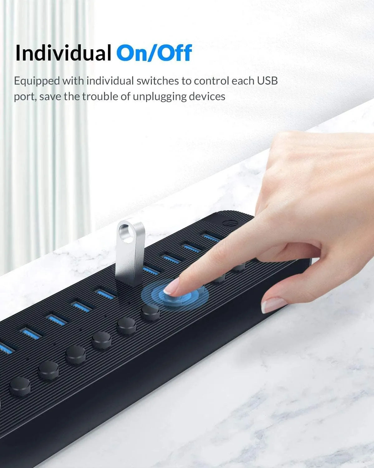 USB hub with individual on/off switches being controlled by a hand, on a marble surface.