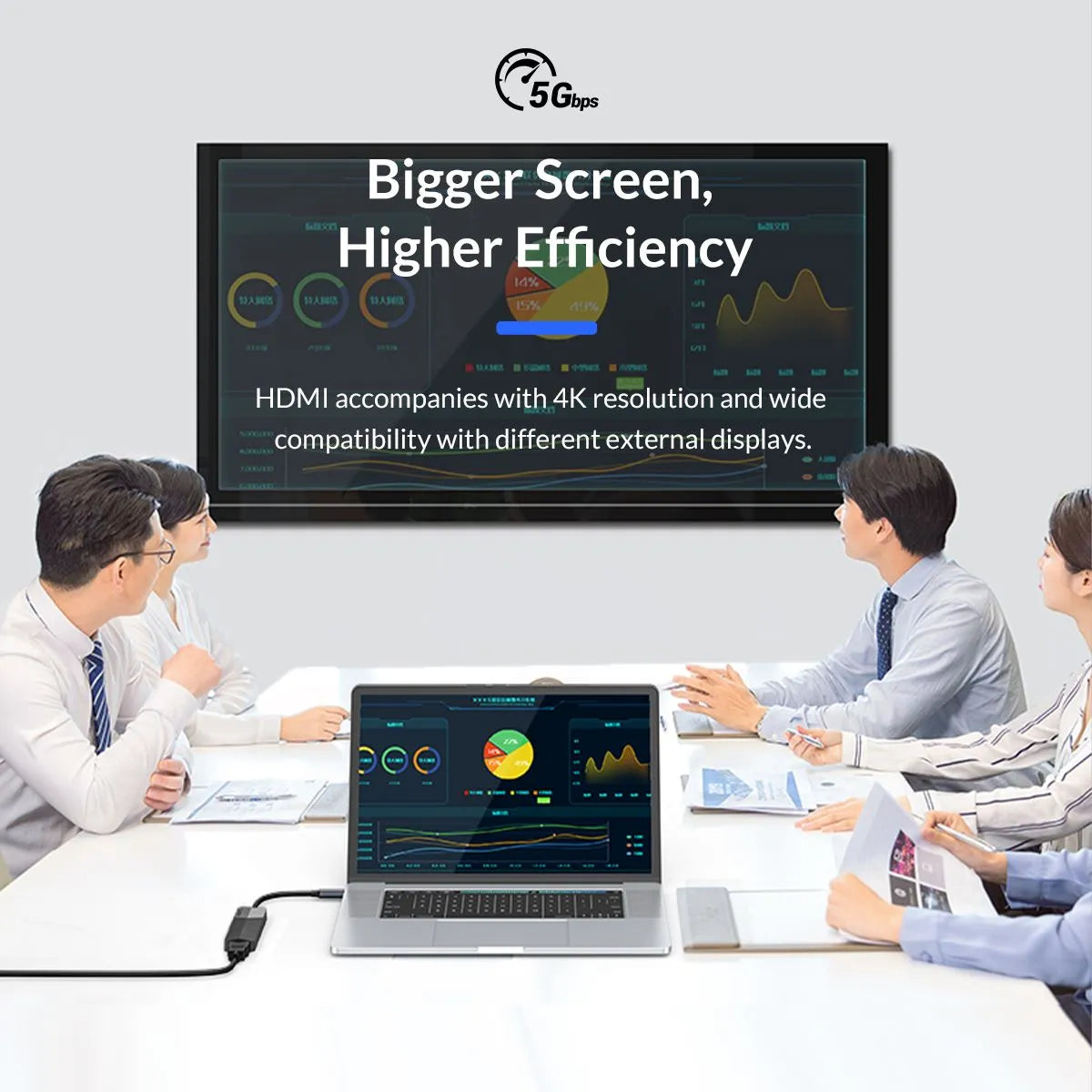 Group of people in a meeting with a large screen displaying 'Bigger Screen, Higher Efficiency' and a laptop in front.