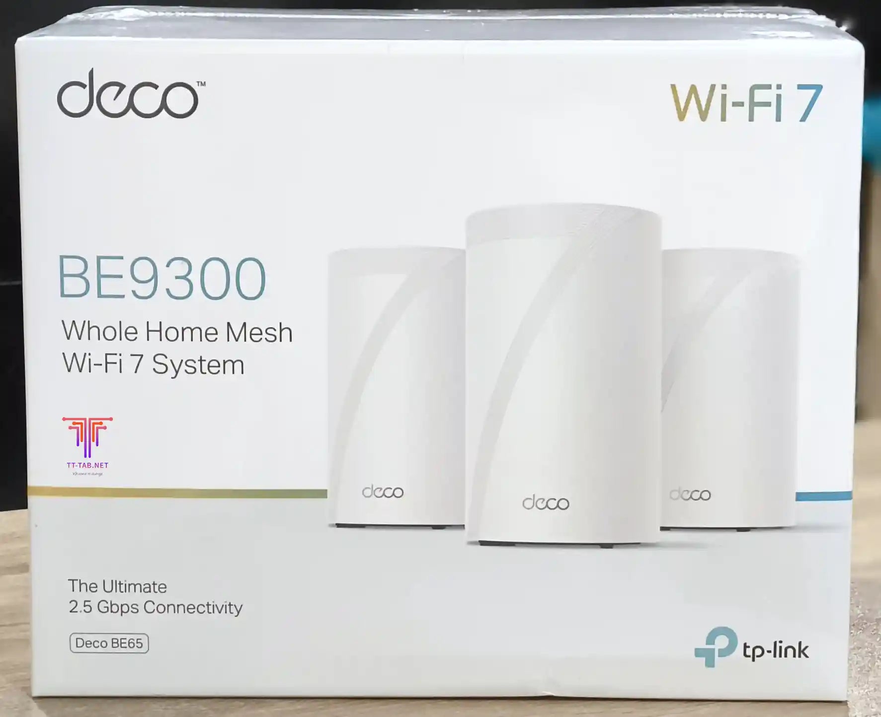 TP-Link Deco BE9300 Whole Home Mesh Wi-Fi 7 System packaging on a wooden surface